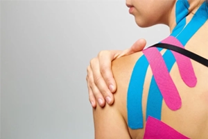 Woman with kinesiology tape on her shoulder